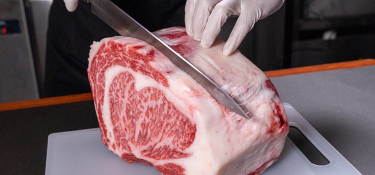 butcher cutting into block of wagyu steak